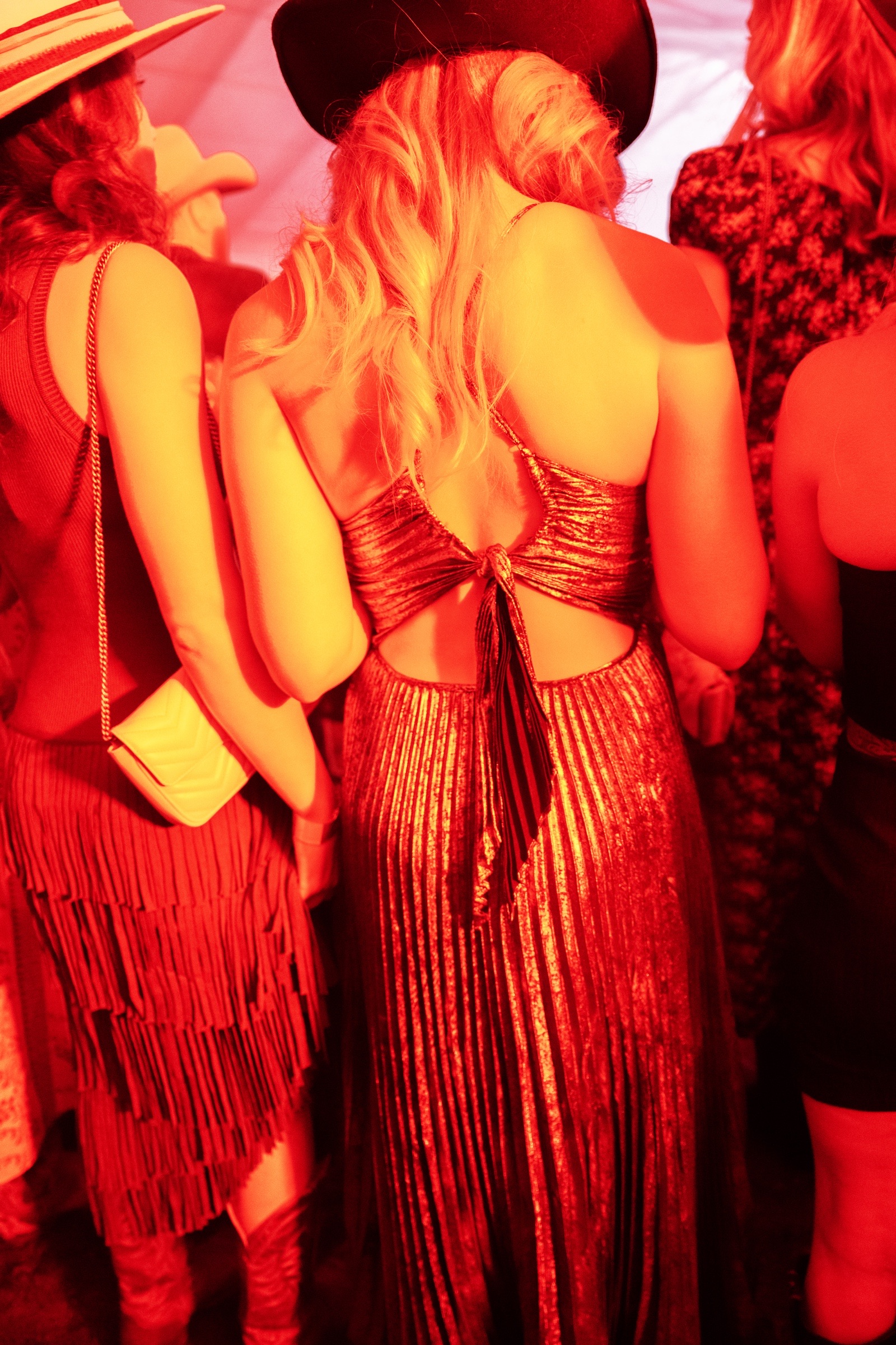 Sequins and cowboy hats glow beneath red light at the Cattle Baron’s Ball