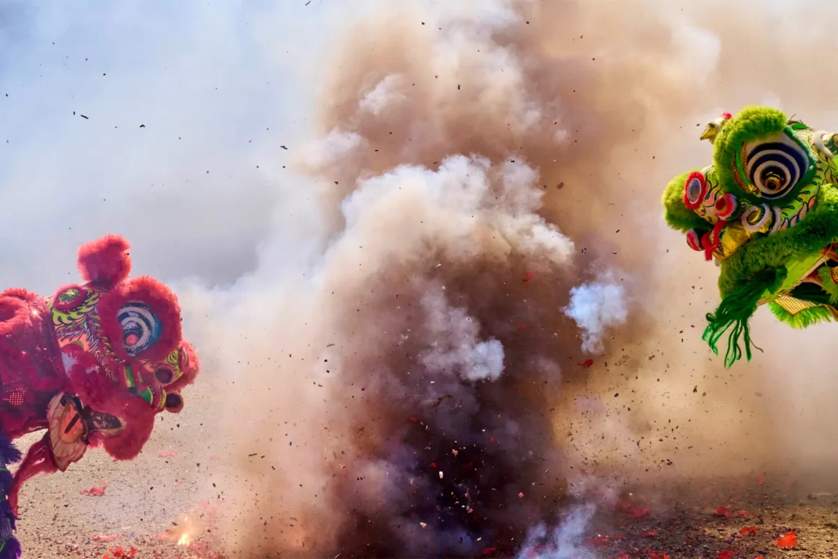 Lion dancers perform amid smoke and firecrackers during Lunar New Year