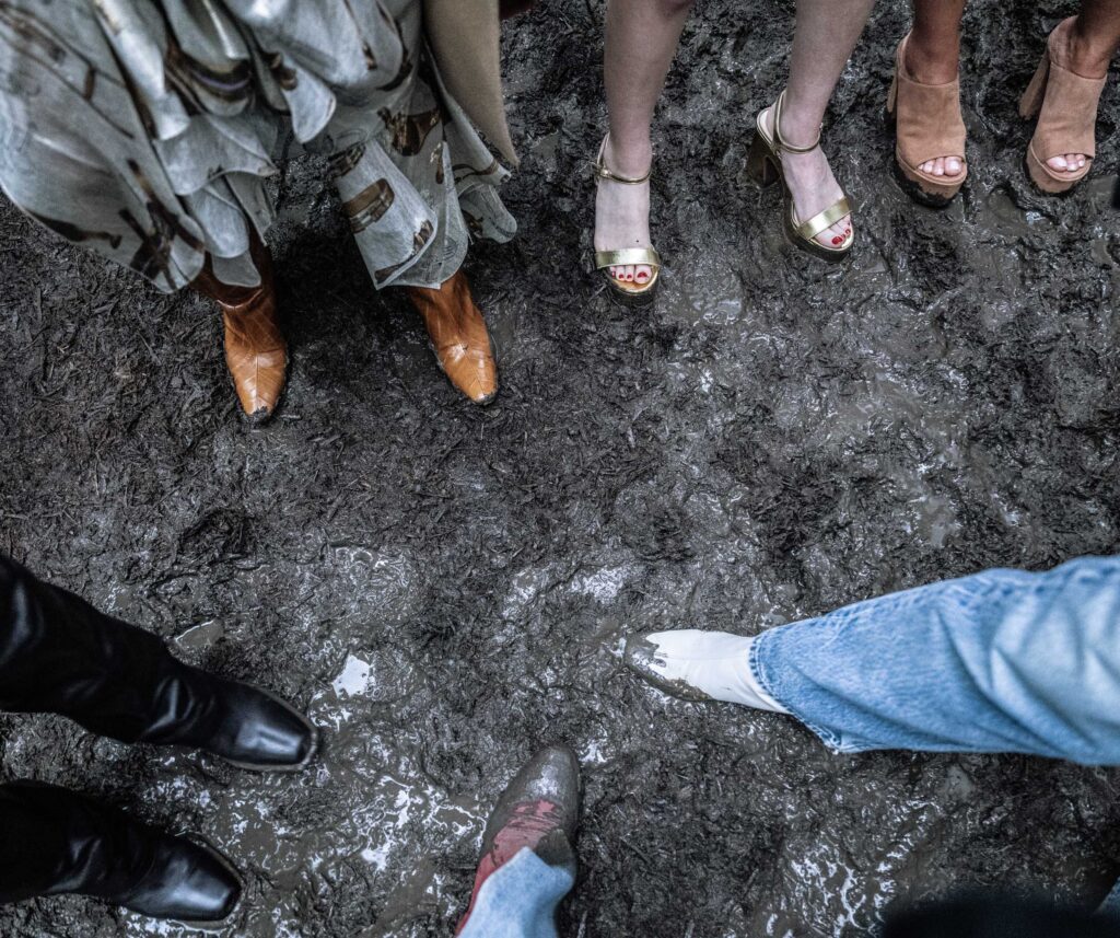 Party shoes and cowboy boots gather in the churned Southfork mud.