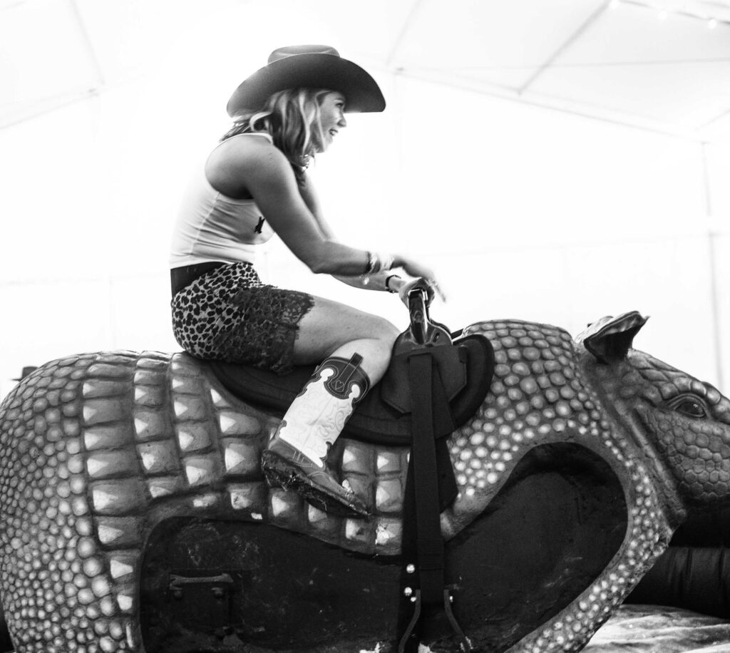 A guest rides a mechanical armadillo beneath the event tent.