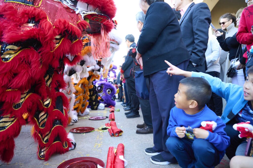 Children meet a row of waiting lions.